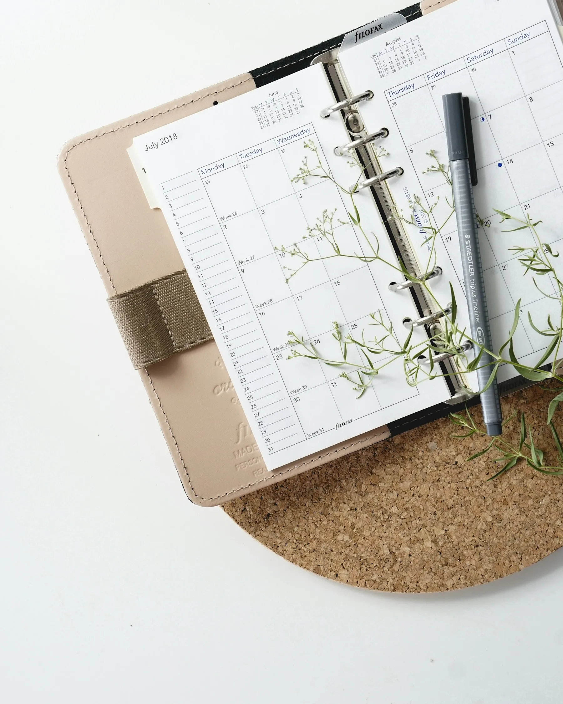 A pen resting on an open calendar