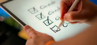 A hand marking off items on a checklist