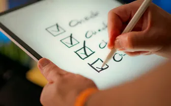 A hand marking off items on a checklist