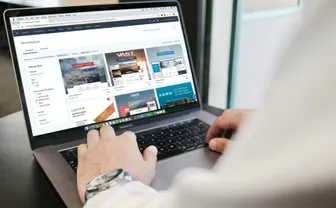 A person browsing a catalog on a laptop