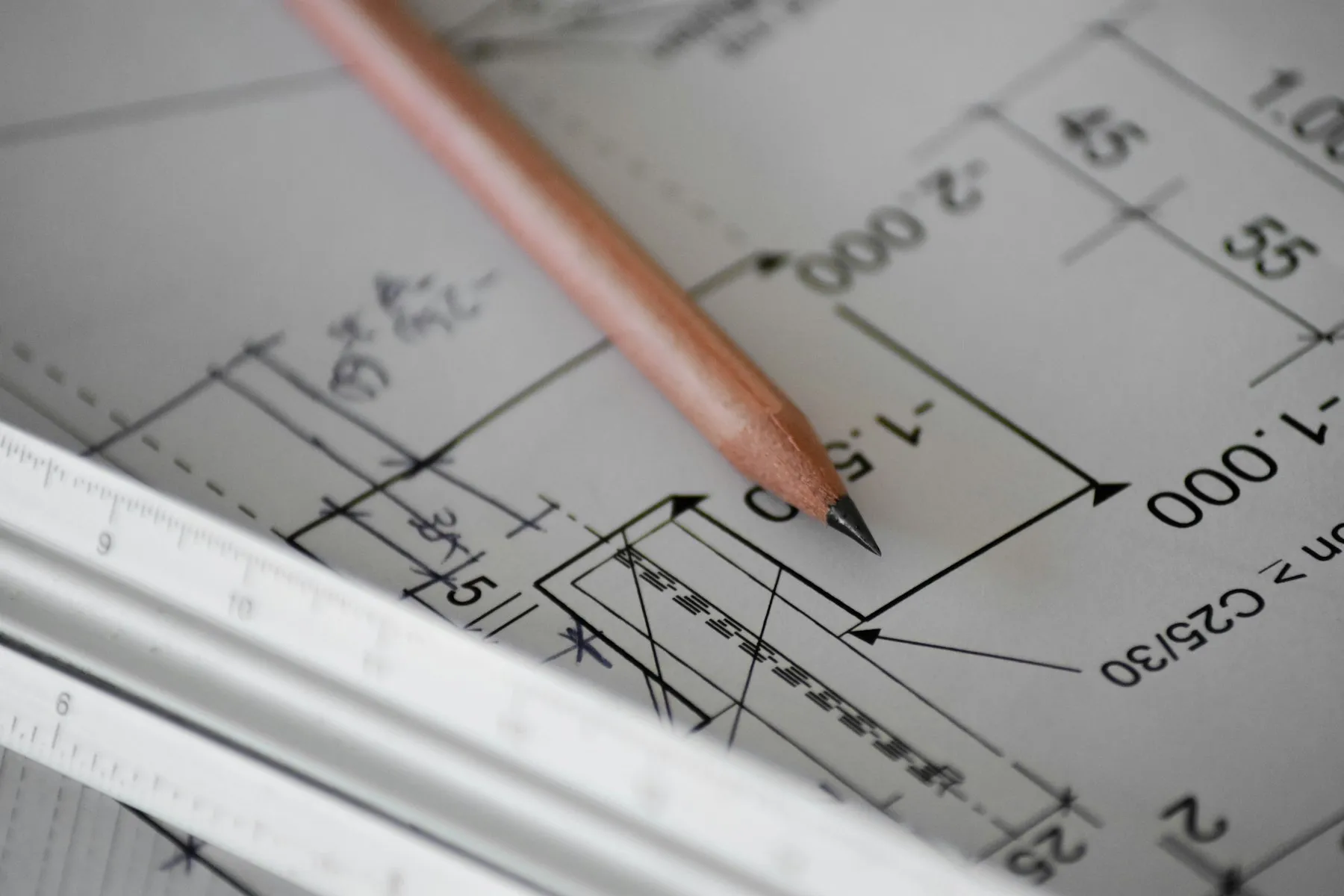 An architectural plan with pencil and scale ruler, mid-draft