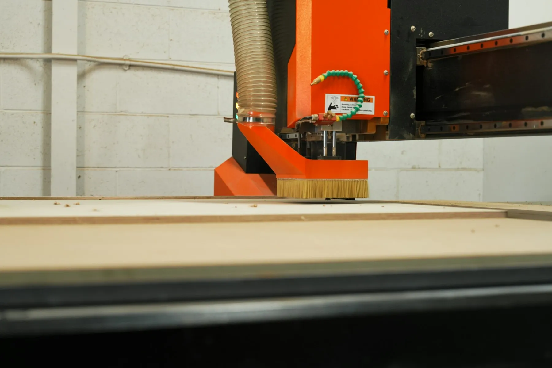 A CNC router cutting a wood panel in a workshop