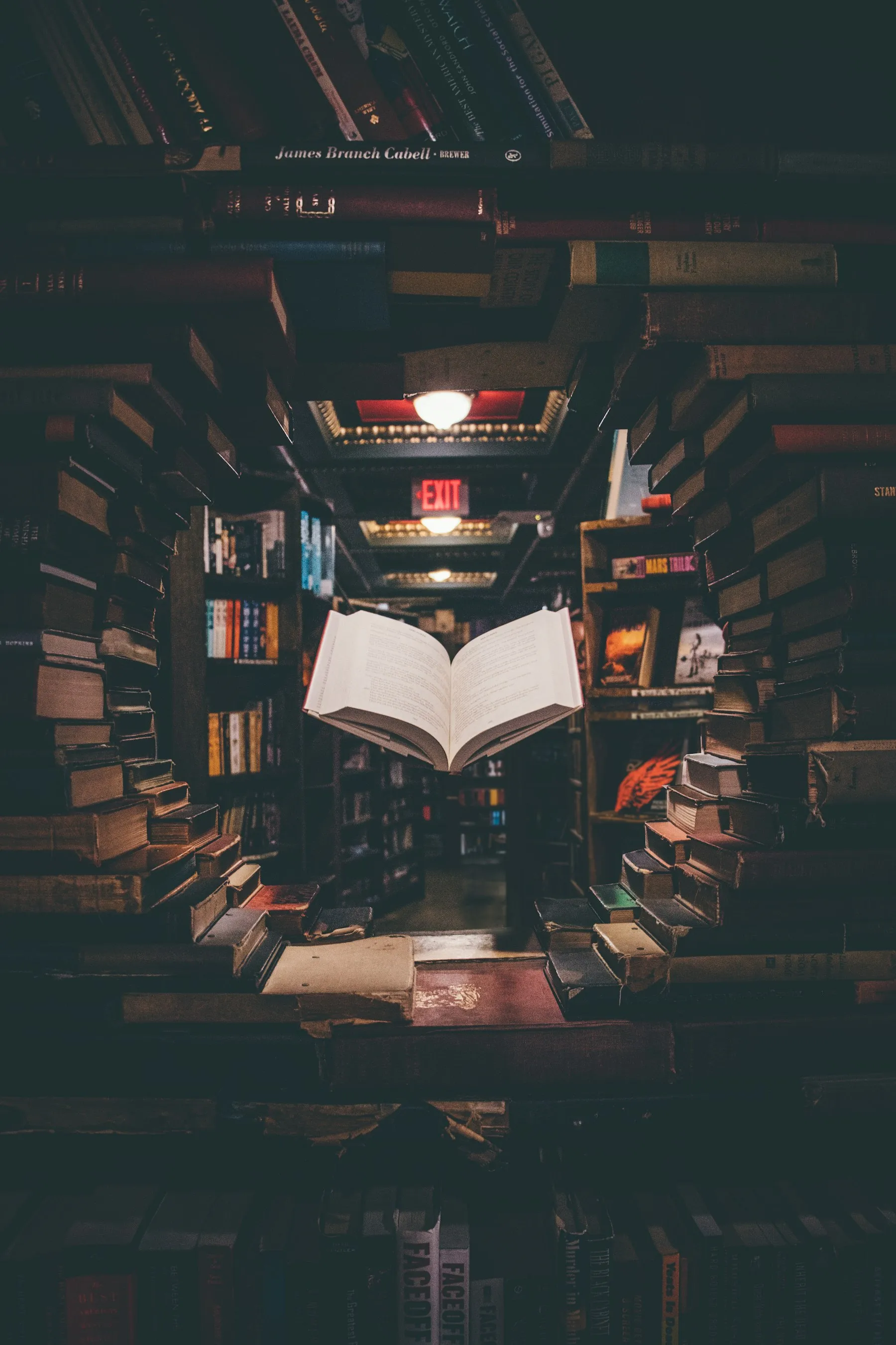 An open reference book among stacked books in a library