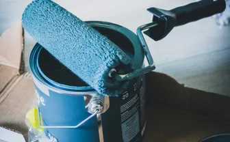 A paint can and roller on a table
