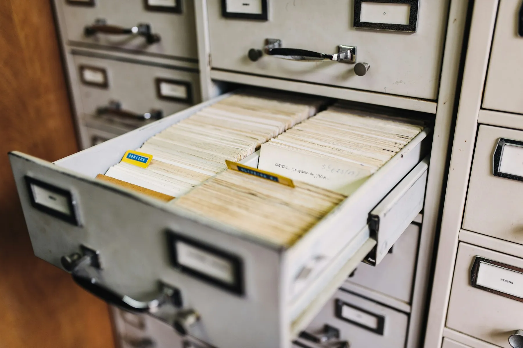 An open vintage file cabinet drawer filled with index cards
