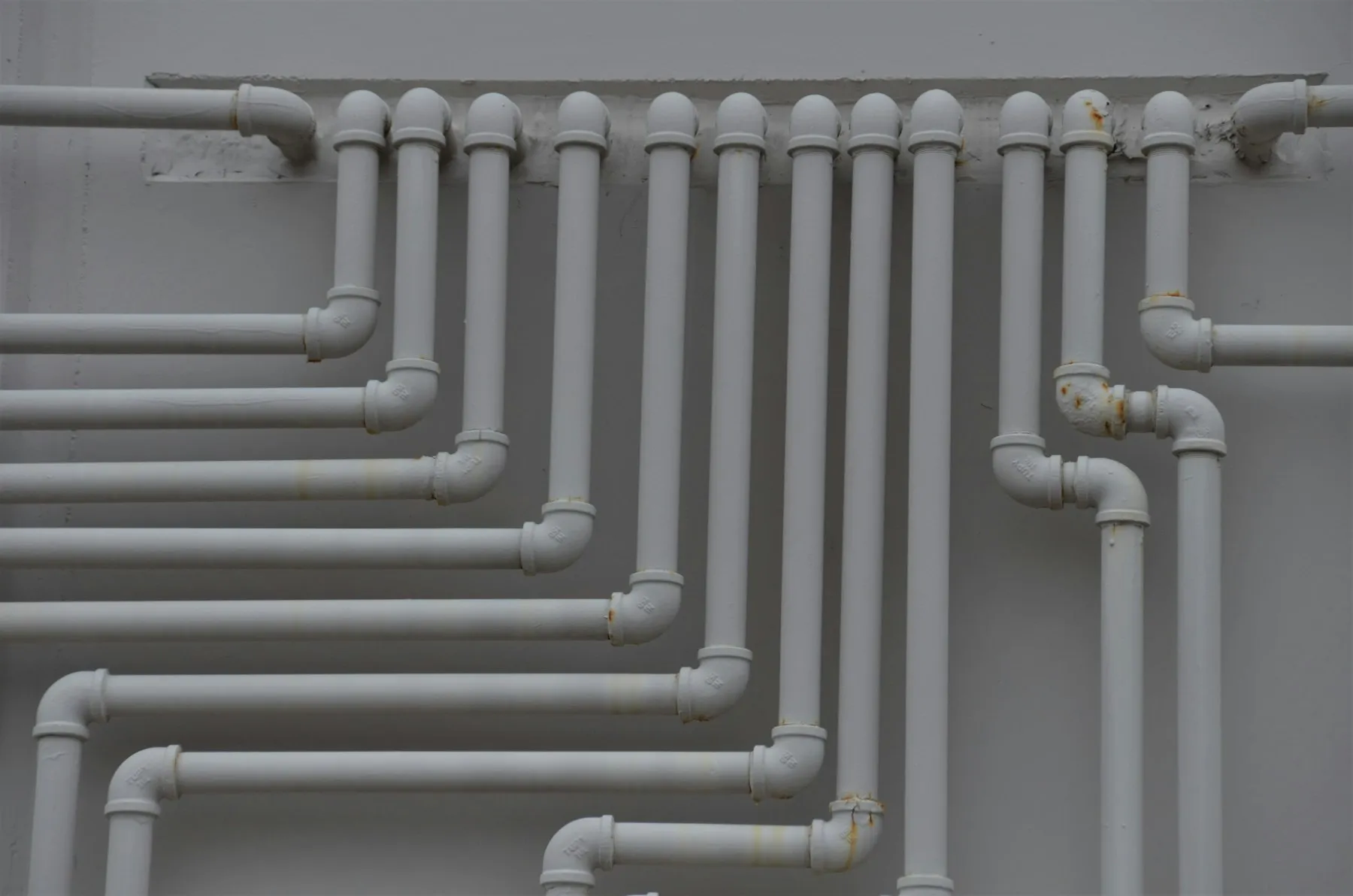 A close-up of white plastic pipes on a wall