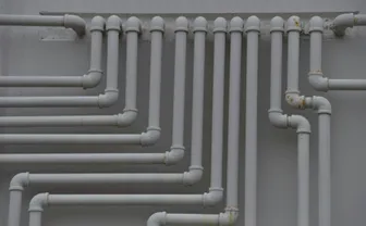 A close-up of white plastic pipes on a wall