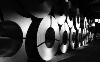 Rolls of steel lined up in a warehouse